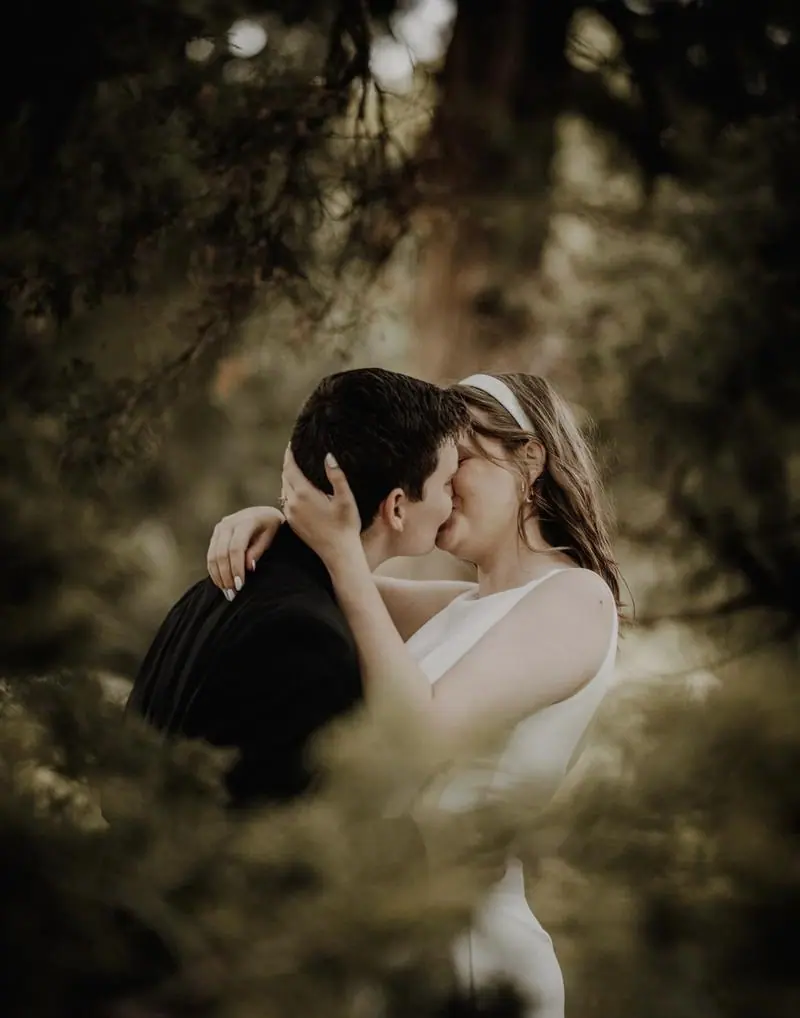 Bride and groom kissing among trees romantic Oklahoma wedding photographer